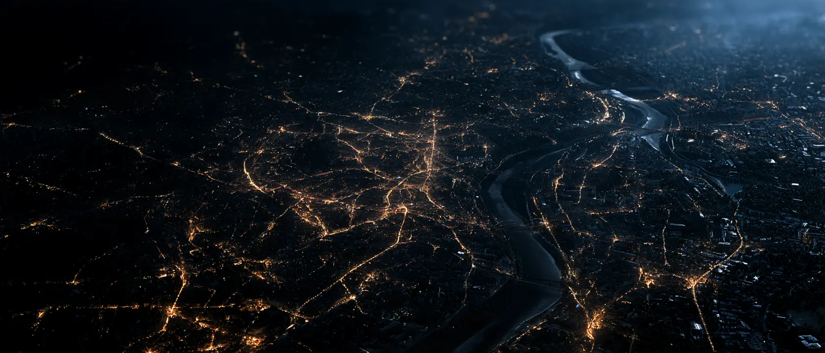 Nocna panorama miasta z lotu ptaka: ulice rozświetlone ciepłym światłem latarni